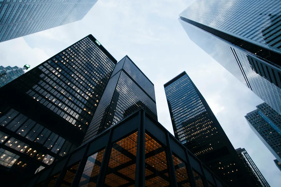 Looking up the layered glass facade of a high-rise building